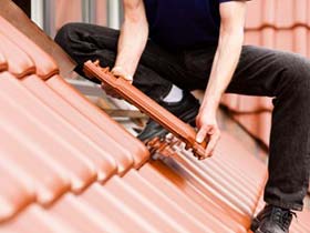 one of our roofers is installing clay tiles, which is part of our Sacramento roofing services